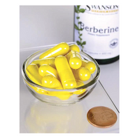 Thumbnail for A small glass bowl holds yellow capsules beside a penny for scale, highlighting their size. In the background is a bottle labeled 