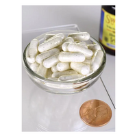 Thumbnail for A glass bowl with white capsules, crafted for immune support, sits beside a penny for size comparison. In the background stands a bottle labeled 