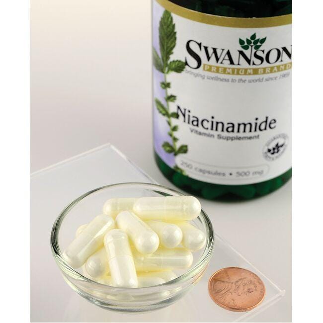 Swanson Vitamin B-3 Niacinamide capsules with a penny next to them. These dietary supplements are specifically designed to support cardiovascular health and healthy joint function through effective ingredients that optimize carbohydrate metabolism.