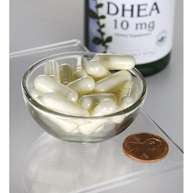 Um frasco de Swanson DHEA - 10 mg 120 capsules numa mesa ao lado de uma taça de comprimidos.