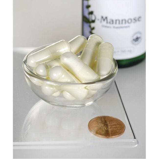 Uma taça de vidro com um frasco de Swanson D-Mannose - 700 mg 60 capsules.