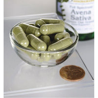 Miniatura de Uma taça de Swanson Avena Sativa - 400 mg 60 capsules ao lado de uma garrafa de azeite.