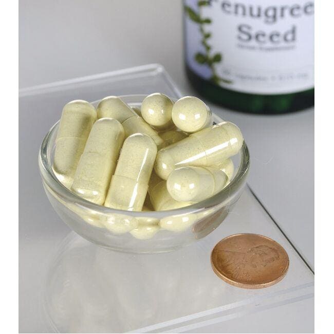 Um frasco de Swanson Fenugreek Seed - 610 mg 90 capsules está ao lado de uma tigela de cápsulas.