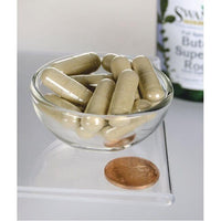 Miniatura de Swanson Butea Superba Root - 400mg dietary supplement capsules ao lado de uma moeda numa tigela.