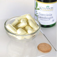 Thumbnail para Um frasco de Swanson's Garcinia Cambogia 5:1 Extract - 60 cápsulas e uma moeda sobre uma mesa.