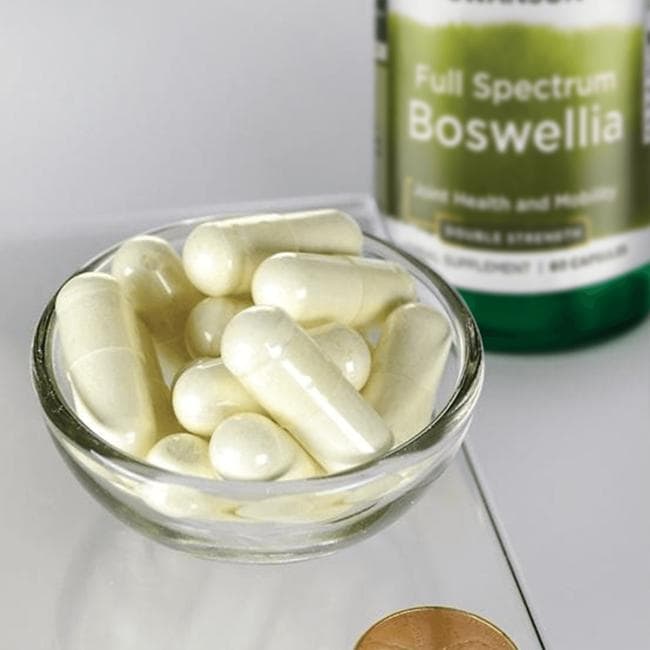 Um suplemento alimentar, Swanson Boswellia, é apresentado com 60 cápsulas ao lado de um cêntimo numa balança.