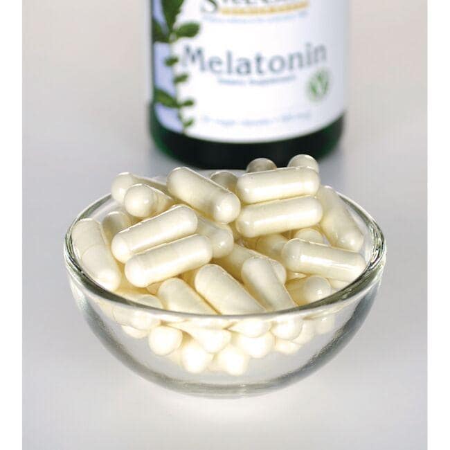 Swanson Melatonin - 0,5 mg 60 cápsulas vegetais numa taça de vidro junto a um frasco.