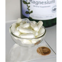Miniatura de Swanson Óxido de Magnésio - 200 mg 500 cápsulas numa tigela ao lado de um frasco.