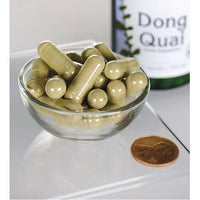 Miniatura de Swanson Dong Quai - 530 mg 100 cápsulas numa taça ao lado de um frasco.