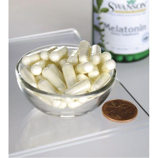 Swanson Melatonin - 1 mg 120 cápsulas numa taça ao lado de um frasco de Swanson Melatonin.