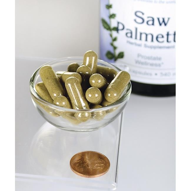 Swanson Saw Palmetto - 540 mg 250 cápsulas, conhecidas pelo seu papel na promoção da saúde da próstata e do fluxo do trato urinário, são apresentadas numa taça ao lado de uma moeda.