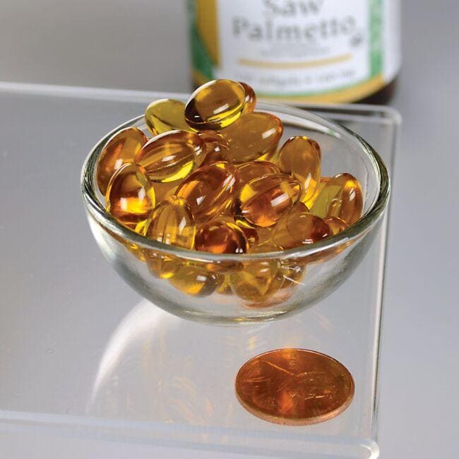 Uma taça de Swanson Saw Palmetto - 160 mg 120 softgel ao lado de uma moeda, promovendo a saúde da próstata.