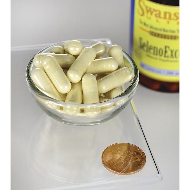 Um frasco do suplemento SelenoExcell Selenium - 200 mcg 60 capsules da Swanson e um cêntimo ao lado de uma taça de comprimidos, promovendo os cuidados cardiovasculares.
