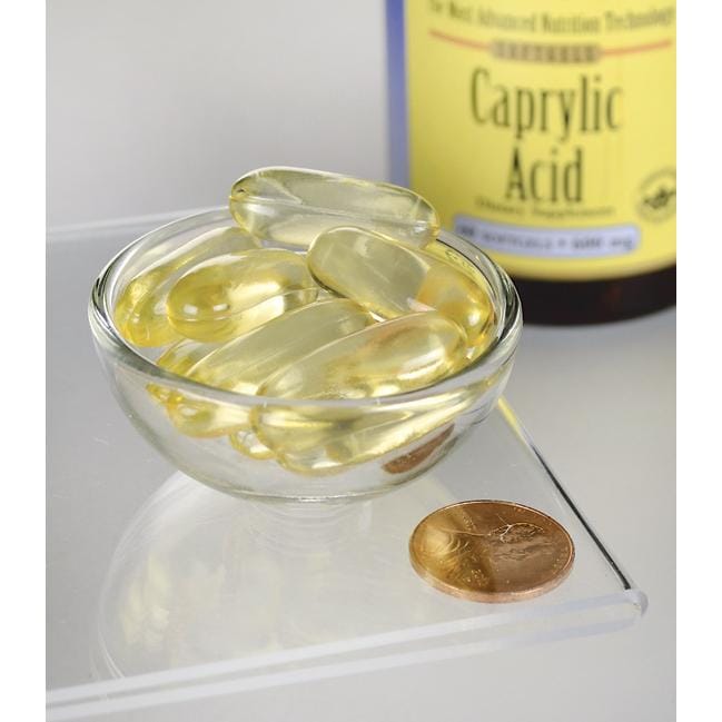 SwansonÁcido Caprílico - 600 mg 60 cápsulas moles de suplemento alimentar numa taça junto a uma moeda.