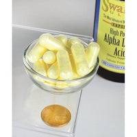 Miniatura de um frasco de Swanson Alpha Lipoic Acid - 600 mg 60 capsules com uma moeda ao lado.