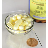 Thumbnail for Um frasco de Swanson Alpha Lipoic Acid - 300 mg 120 capsules está ao lado de uma moeda de um cêntimo.