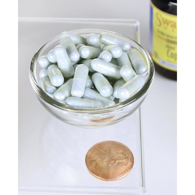 Uma taça de Swanson Copper - 2 mg 60 capsules Albion Chelated ao lado de um cêntimo.
