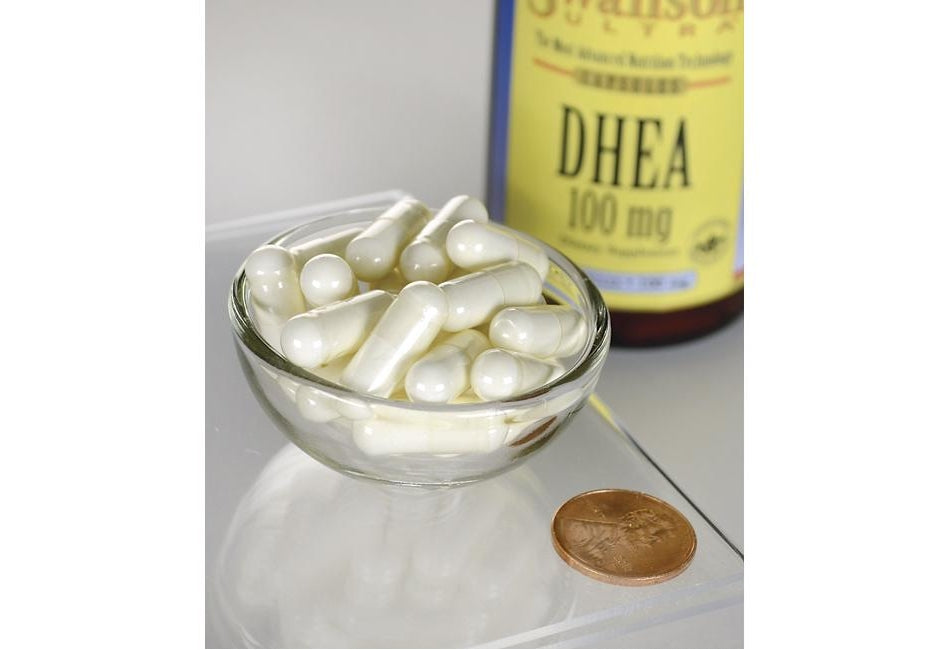 Swanson DHEA - 100 mg 60 cápsulas numa taça ao lado de uma moeda.